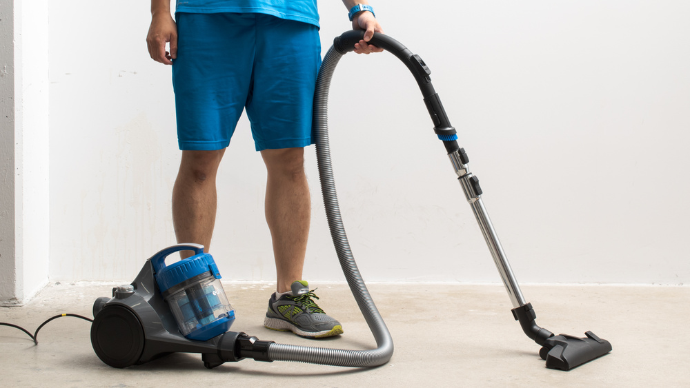 man-using-canister-vacuum